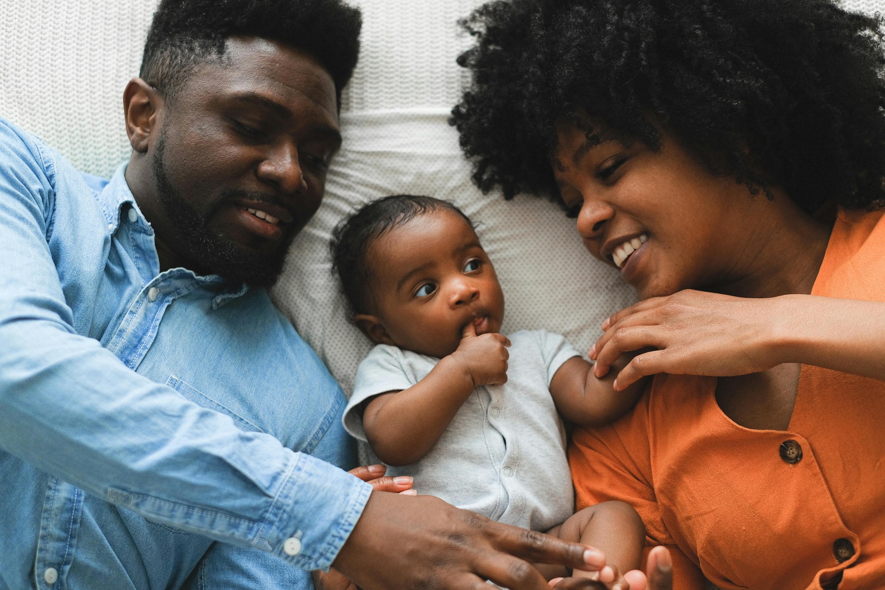 Couple laying down with their newborn baby