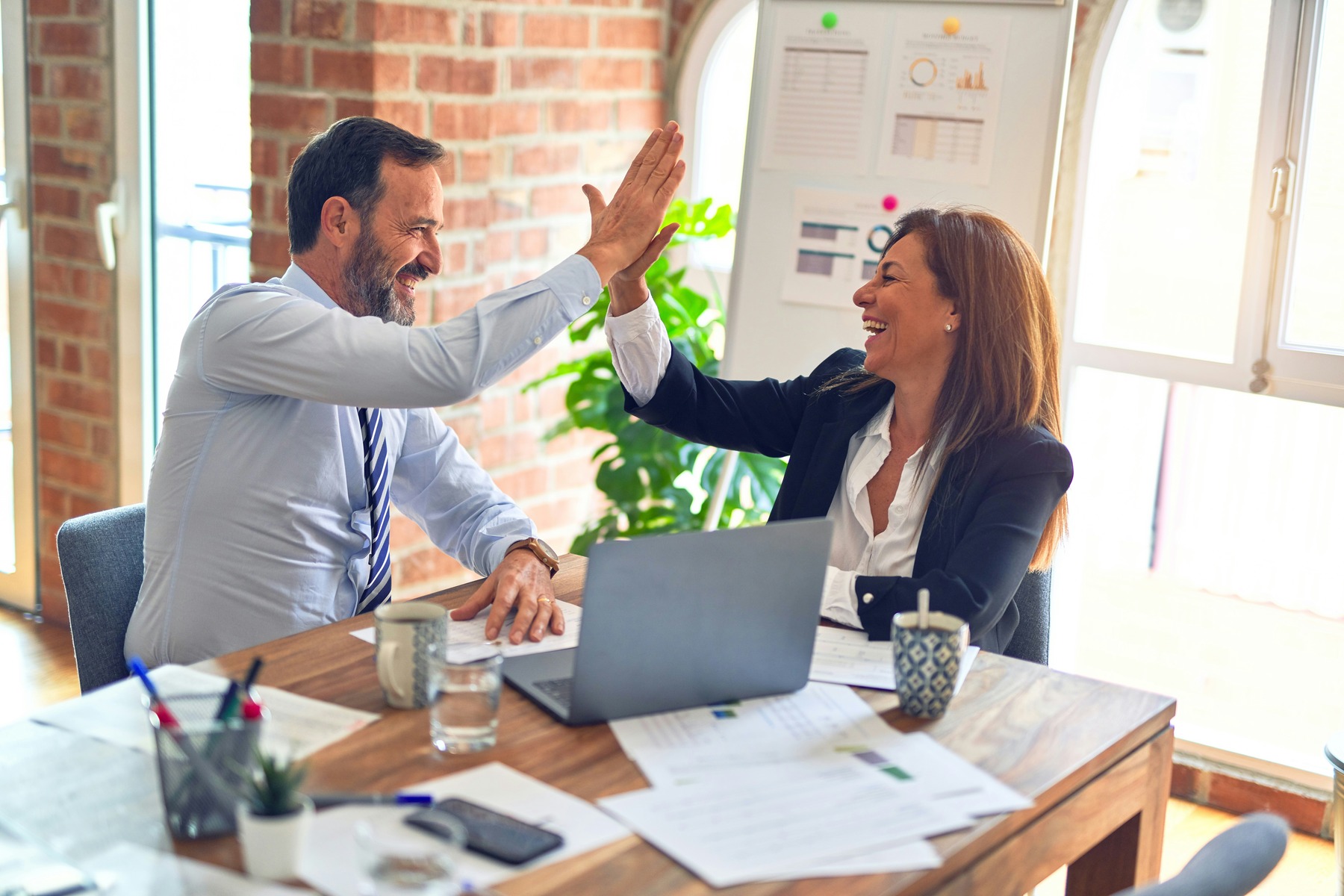 Two people giving high fives after completing work