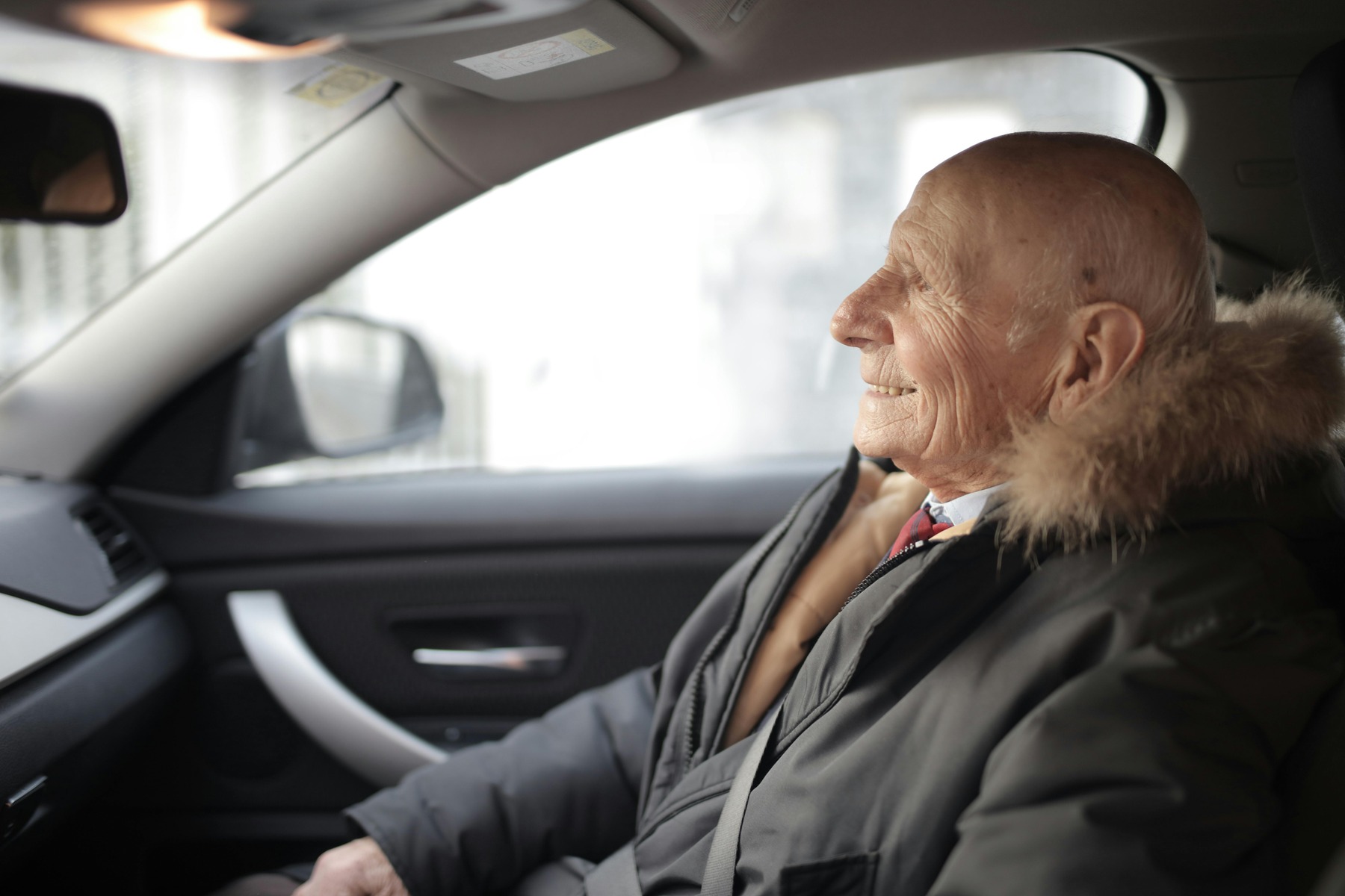 Elderly man sitting inside a car