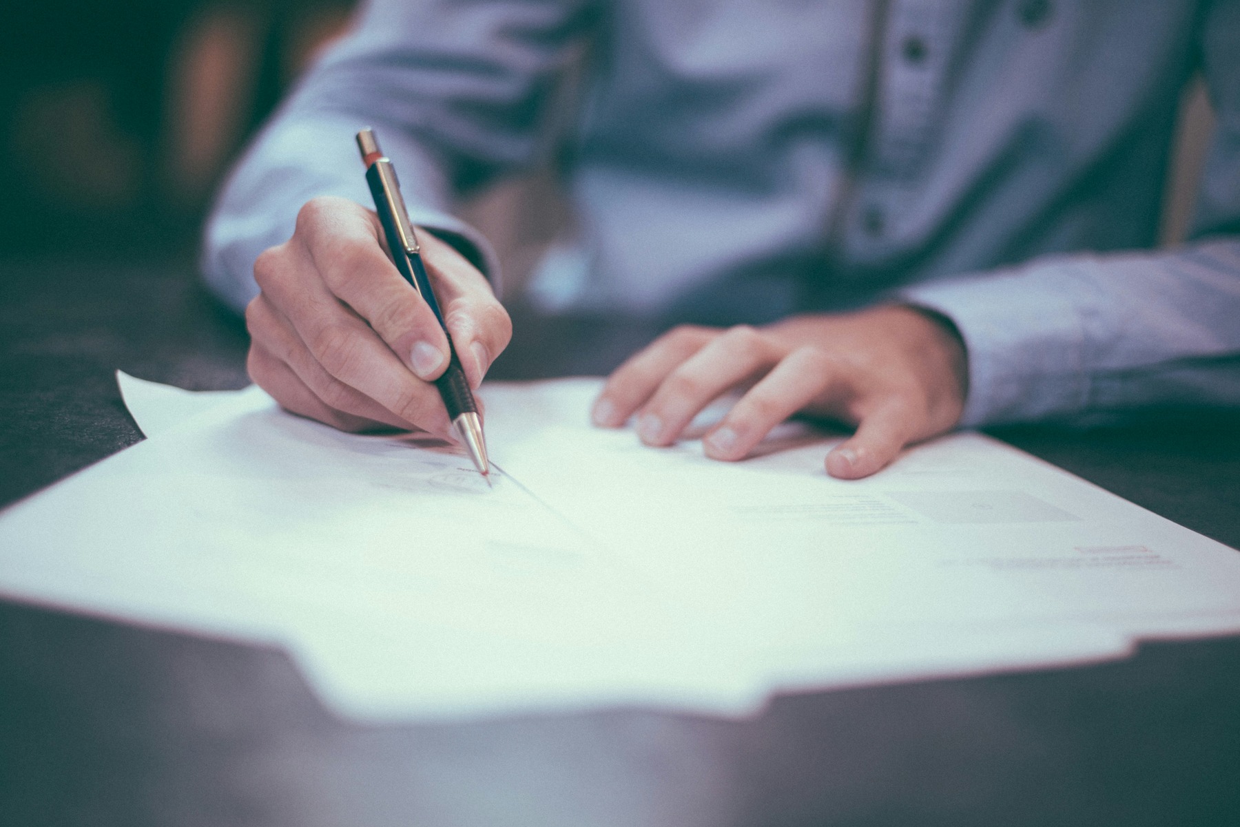 Man signing printed documents