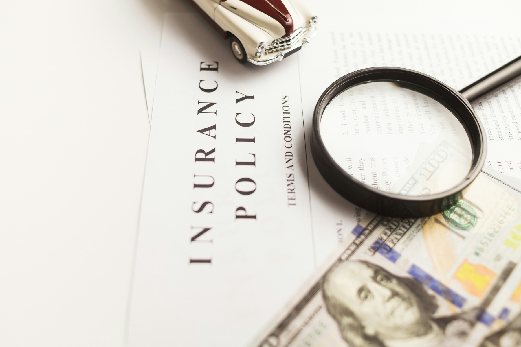 Magnifying glass on top of insurance policy document 