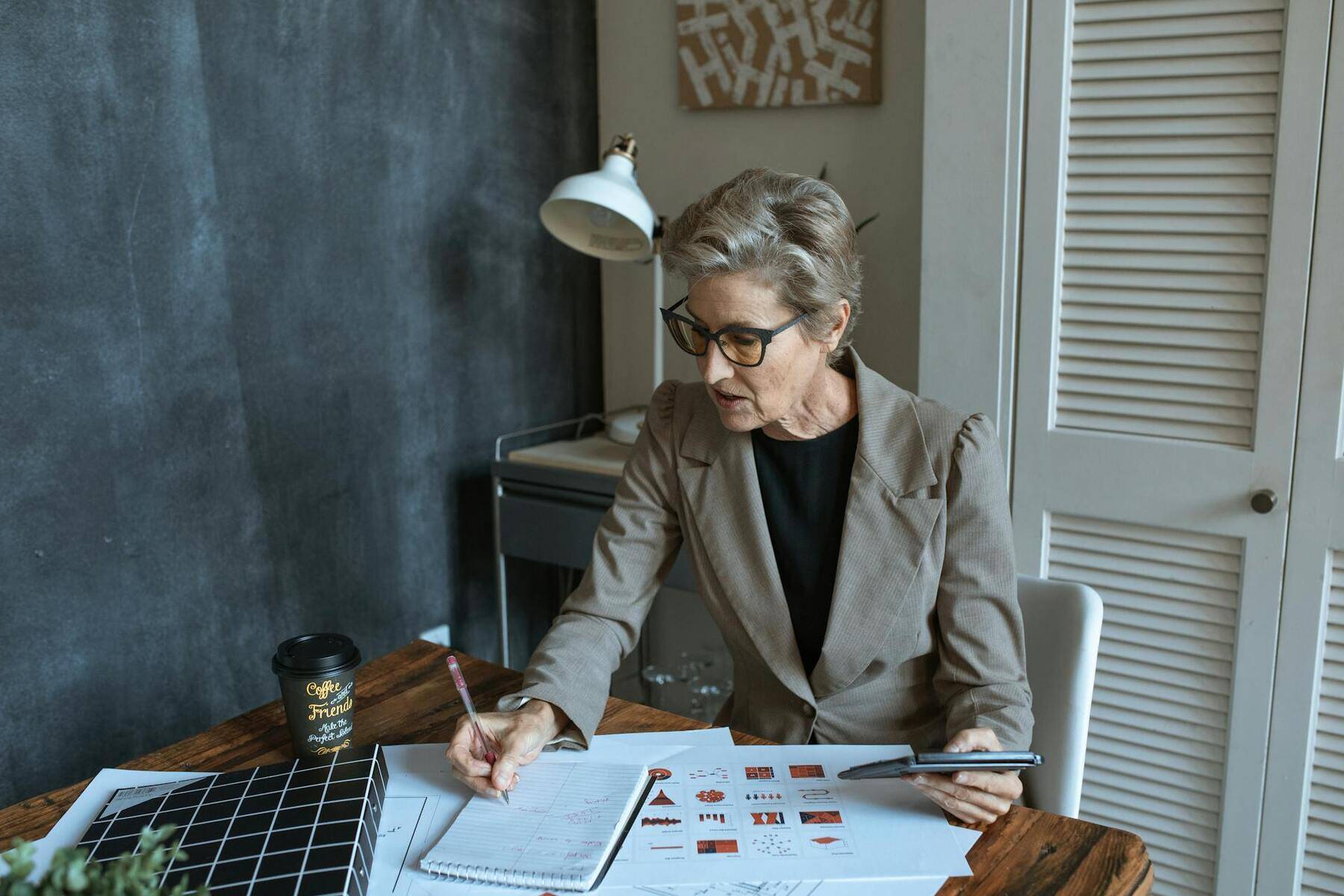 A professional woman in a business suit diligently works on paperwork