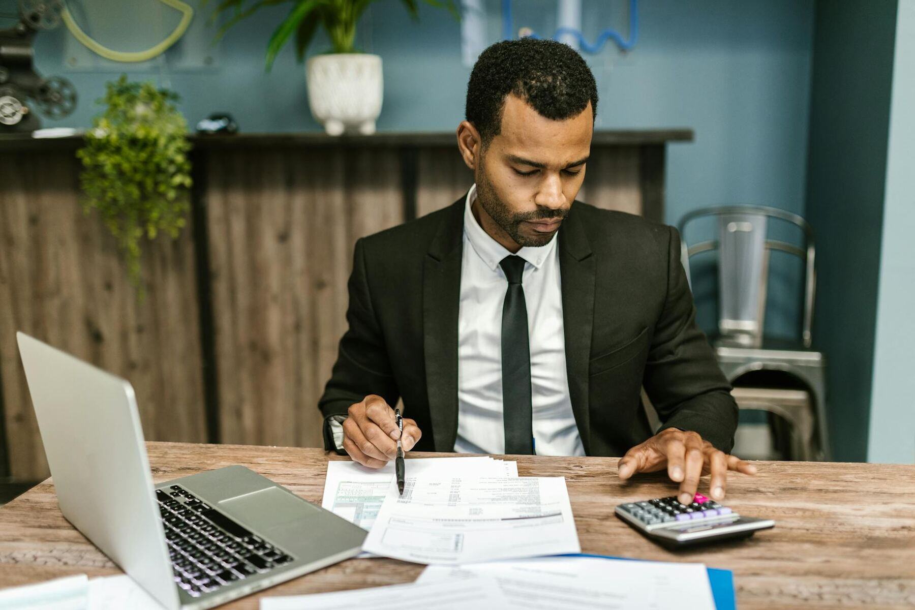A businessman in a suit sitting at a desk, focused on paperwork