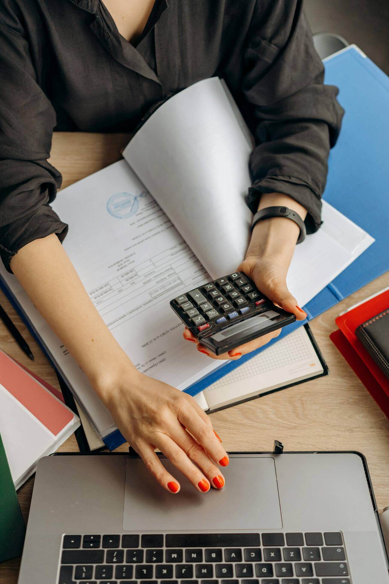 A woman calculating taxes on a calculator